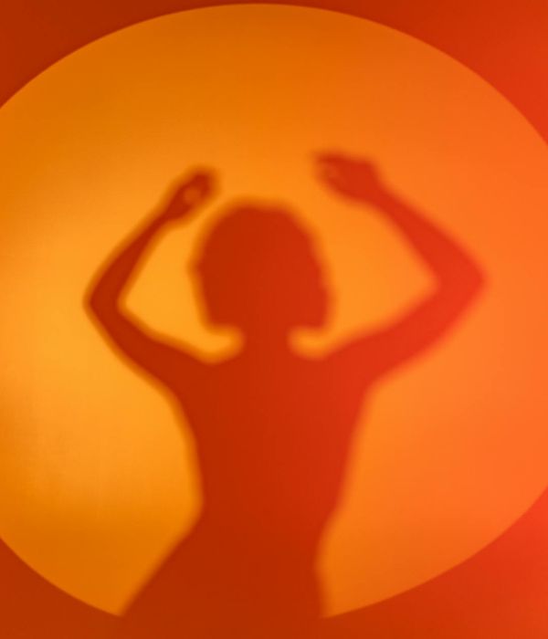 Woman performing a fluid cardio movement in a bright studio.